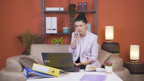 Mujer-Joven-Trabajadora-De-Oficina-En-Casa-Que-Tiene-Problemas-Y-Estrés-Por-Teléfono.
